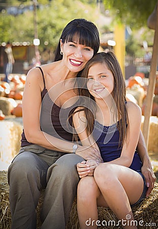 Attractive Mother and Daughter Portrait at the Pumpkin Patch Stock Photo