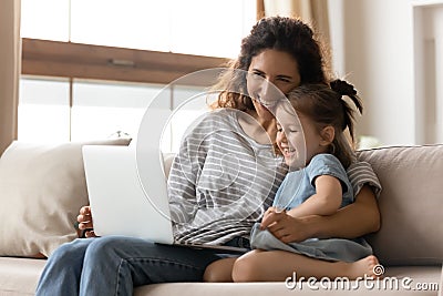 Mother and little daughter having fun watching cartoons on laptop Stock Photo