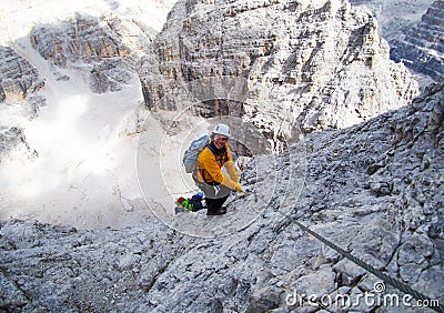 Attractive mountain climber on a steep and hard Via Ferrata climb in the Italian Dolomites Stock Photo