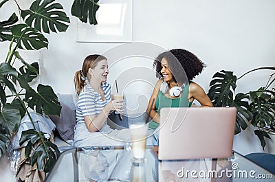 Attractive multiracial teenagers drink cappuccino and chat. Funny teen girls talk and have good time together Stock Photo