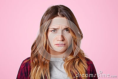 Attractive offended female with dissatisfied expression, curves lips, going to cry as being abused by close person, didn`t expect Stock Photo