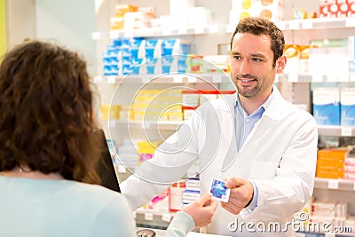 Attractive pharmacist taking healt credit card Stock Photo