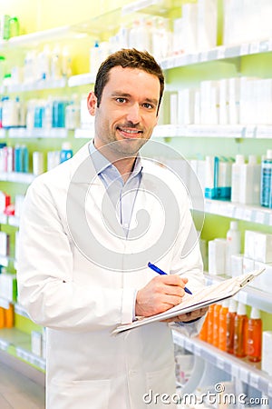 Attractive pharmacist taking notes at work Stock Photo