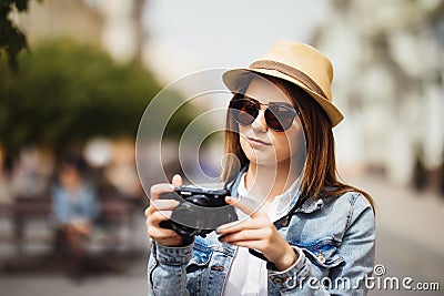 Attractive photographer woman tourist using camera outdoors in new city Stock Photo