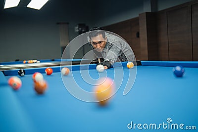 attractive pool player pooking the white ball while starting the game Stock Photo