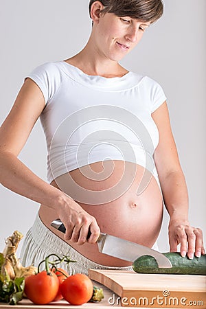 Attractive pregnant woman making a healthy salad Stock Photo