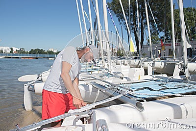 Attractive sailor rigging hobbie-cat before sailing course Stock Photo