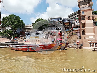 Attractive scene of boats floating in the river with trees and building in the bank of river Ganga Editorial Stock Photo