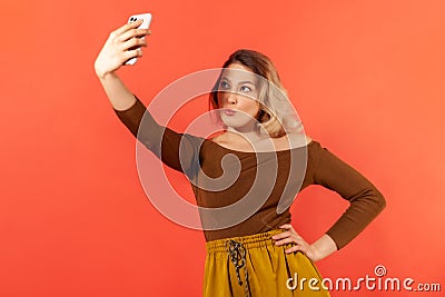 Attractive self confident woman blogger making selfie, posing to camera of her smartphone Stock Photo