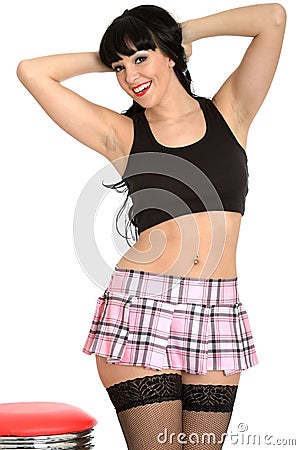 Attractive Glamorous Young Classic Pin Up Model In Fishnet Stockings and Pleated Mini Skirt Stock Photo