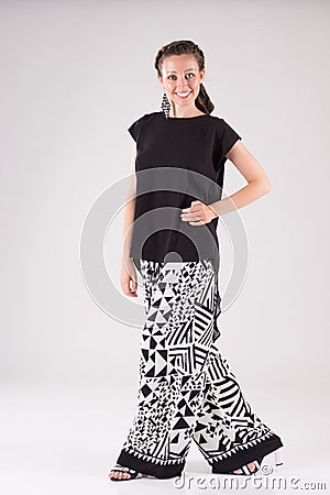 Attractive smiling business woman dressed in wide black and white trousers and black blouse. Stock Photo