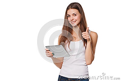 Attractive smiling girl in white shirt using tablet showing thumbs up. Woman with tablet pc, isolated on white background Stock Photo
