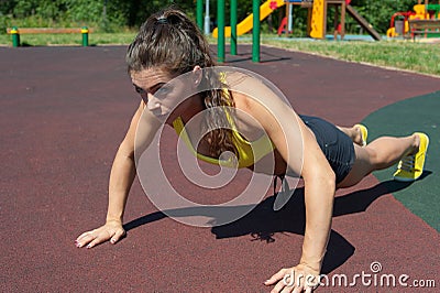 Attractive sport woman push-ups on playground Stock Photo