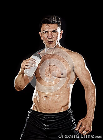 Attractive strong sport man drinking water holding bottle sweating tired after training gym Stock Photo