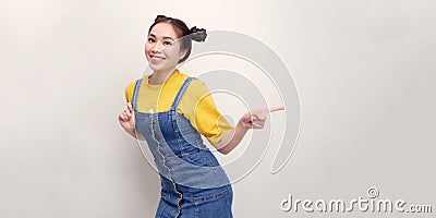 Attractive stylish girl pointing side, advertise promo, smiling camera, look at you as recommend use link, white background Stock Photo