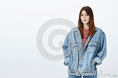 Attractive stylish girlfriend wearing boyfriends denim jacket to get warm during night walk. Calm confident european Stock Photo