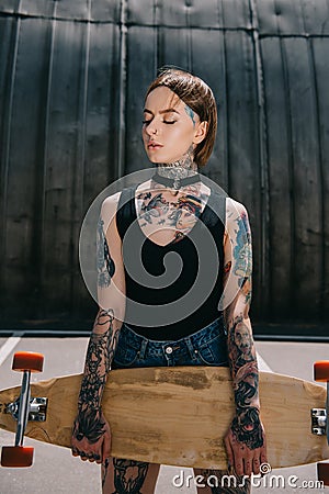 attractive stylish tattooed girl with closed eyes holding Stock Photo