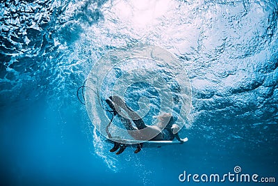 Attractive surfer girl dive underwater with wave Stock Photo