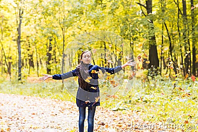 Attractive teen girl throwing leaves in the air Stock Photo