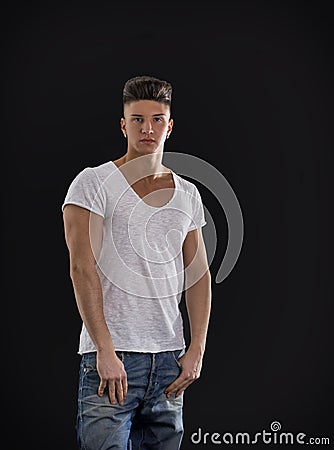 Attractive trendy young man standing on black background Stock Photo