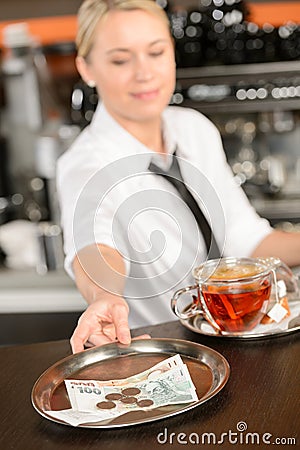 Attractive waitress taking tip in bar CZK Stock Photo