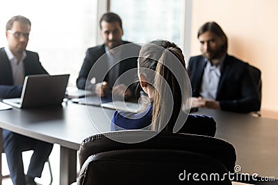 Attractive woman applicant back sitting in front HR businessmen speaking. Stock Photo