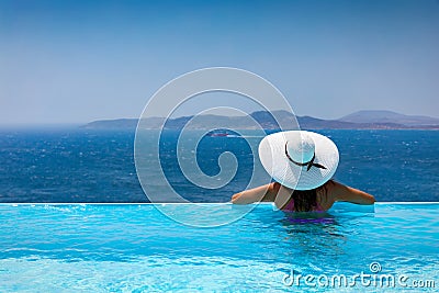 Attractive woman enjoys the view from the pool to the Mediterranean sea Stock Photo