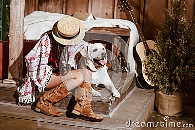 Attractive woman in boho style sitting with a dog in a Stock Photo