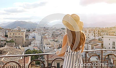 Attractive woman enjoys view of Palermo cityscape from a rooftop terrace, Italy Stock Photo