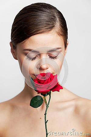 Attractive woman eyes closed sniffing a rose red lips Stock Photo