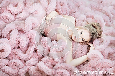 Attractive woman lying on the floor in pink cloud dress. Fashion Stock Photo