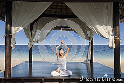 Attractive woman practice yoga at luxury beach resort Stock Photo
