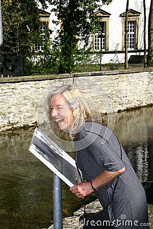 Attractive woman reads information board with indications of a sight Stock Photo