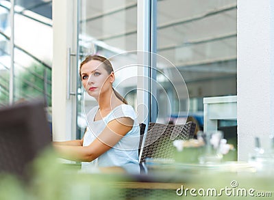 Attractive woman with red lips reads a newspaper sitting in a ca Stock Photo