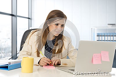 Attractive woman sitting at office chair working at laptop computer desk Stock Photo