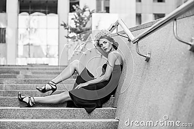 Attractive woman sitting on steps of granite staircase Stock Photo