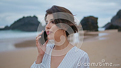 Attractive woman talking mobile phone at shore closeup. Beach lady making call Stock Photo