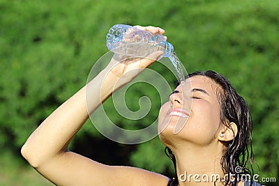 Attractive woman throwing herself water from a bottle Stock Photo
