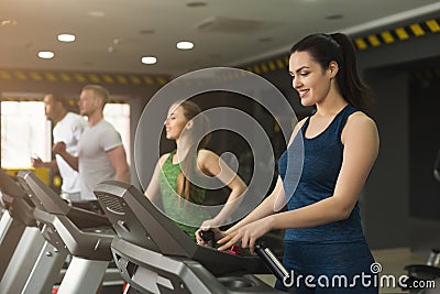 Attractive woman on treadmill in fitness club Stock Photo