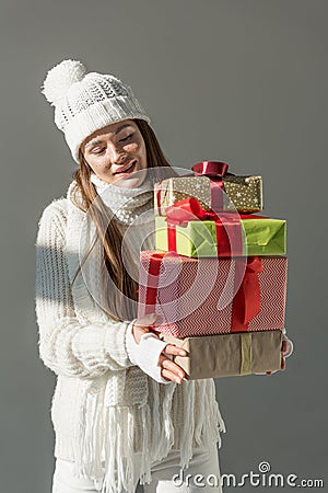 attractive woman in trendy winter sweater and scarf holding presents isolated Stock Photo