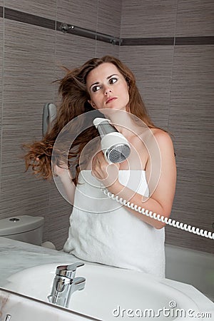 Attractive woman using fen in bathroom Stock Photo