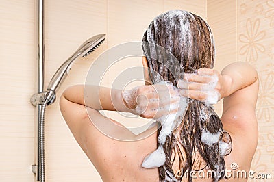 Attractive woman washing her hair with shampoo in shower Stock Photo
