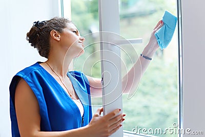 Attractive Woman Washing the Window. Cleaning Company worker wor Stock Photo