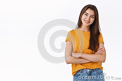 Attractive woman in yellow t-shirt cross hands over chest with self-assured, pleased expression, tilt head and smiling Stock Photo