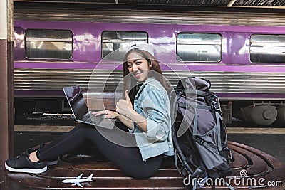 Attractive young Asian lady backpacker using computer laptop for plan to trip. Travel lifestyle concept Stock Photo