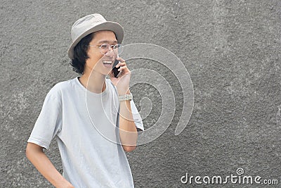 A attractive young asian man with hat and glasses using smarphone Stock Photo