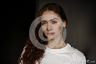 Attractive young beautiful woman in a white T-shirt looks Stock Photo