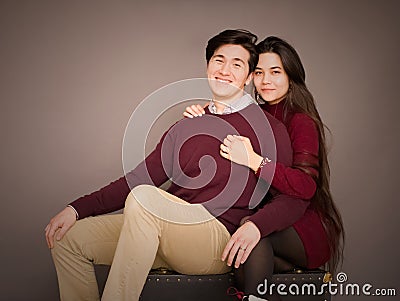 Attractive young biracial couple in burgundy colored sweaters posing Stock Photo