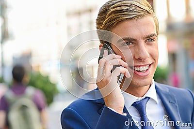 Attractive young businessman on the phone in urban background Stock Photo