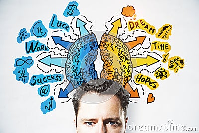 Attractive young european businessman with creative drawing of different brain hemispheres on concrete wall background. Stock Photo